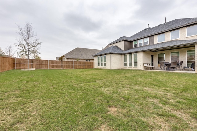 back of house with a yard and a patio