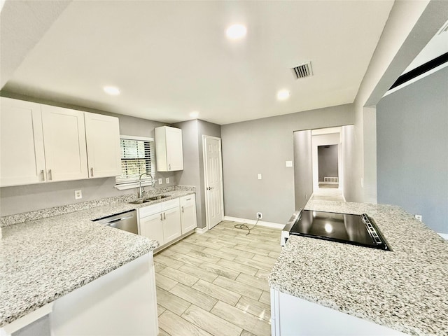 kitchen with white cabinets, stove, light stone countertops, and sink