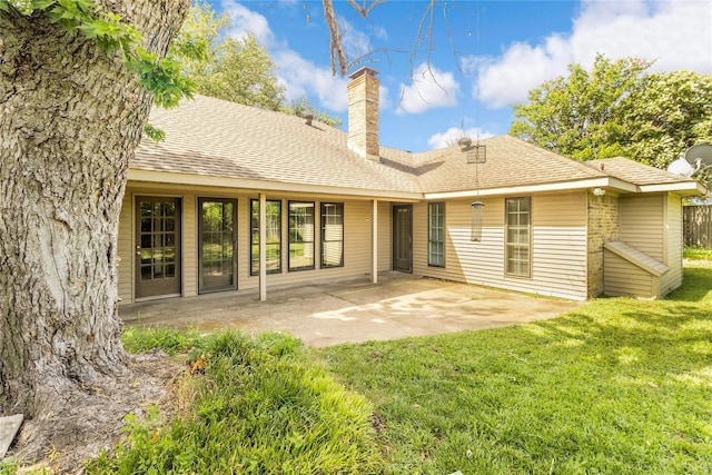 rear view of house with a lawn and a patio