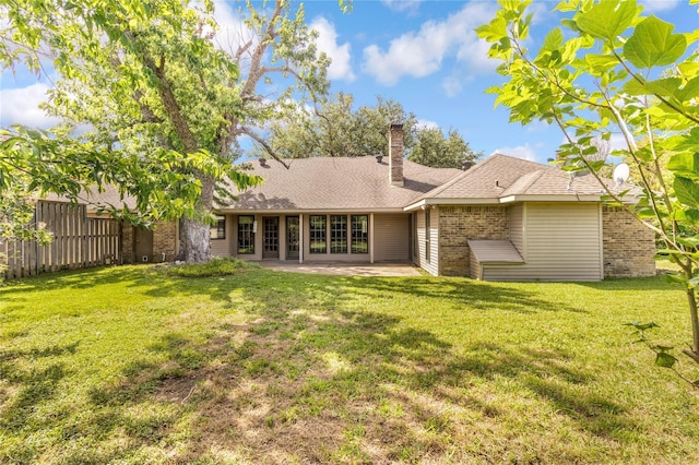 rear view of house featuring a yard and a patio area