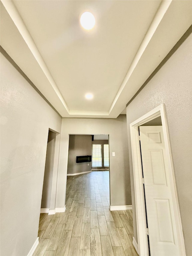 hall featuring a tray ceiling