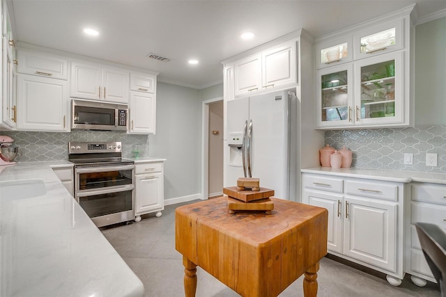 kitchen featuring visible vents, crown molding, light countertops, stainless steel appliances, and white cabinetry