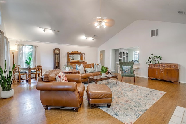 living room featuring high vaulted ceiling, light hardwood / wood-style floors, and ceiling fan