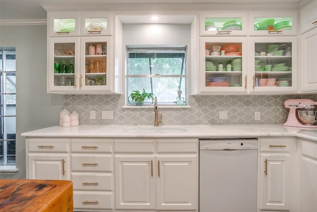 kitchen featuring white cabinets, a sink, dishwasher, light countertops, and backsplash