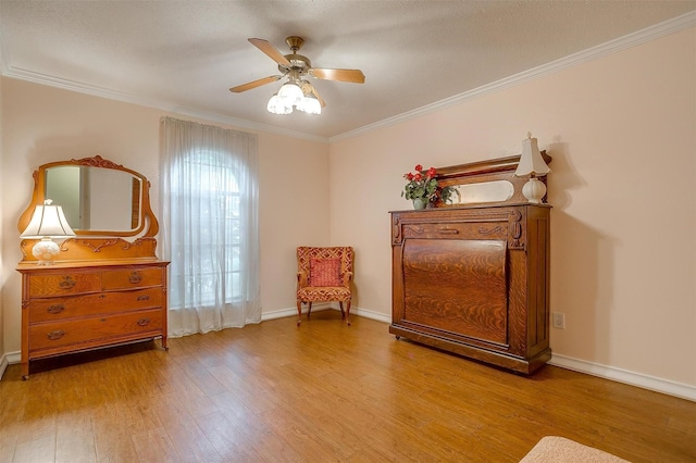 living area with ornamental molding, light hardwood / wood-style floors, and ceiling fan