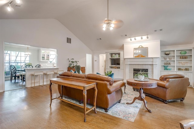 512 N Parkridge Dr, Mansfield, TX 76063 - living room featuring a ceiling fan, rail lighting, a tiled fireplace, wood finished floors, and lofted ceiling