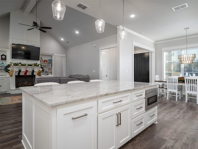 kitchen featuring pendant lighting, dark hardwood / wood-style floors, built in microwave, a kitchen island, and white cabinetry