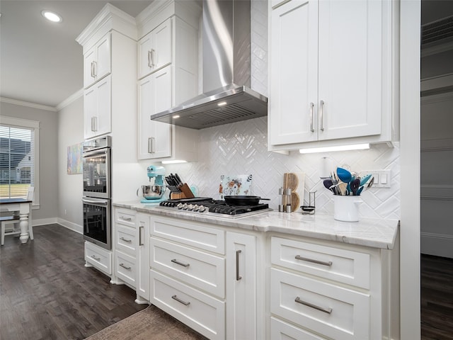 kitchen with white cabinetry, wall chimney exhaust hood, dark hardwood / wood-style flooring, crown molding, and appliances with stainless steel finishes