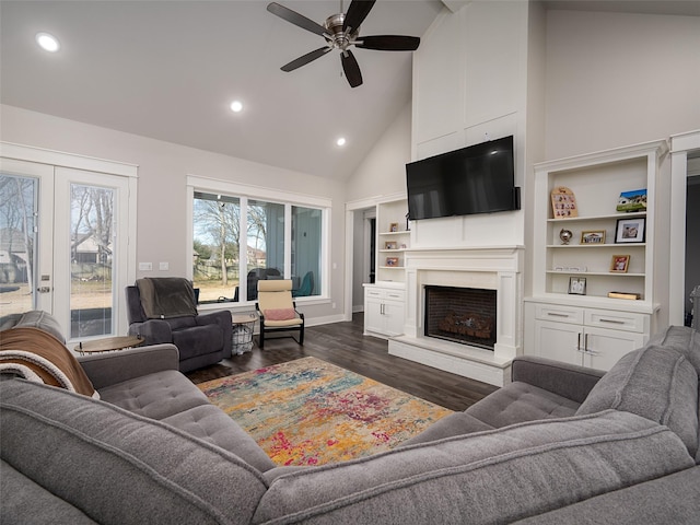 living room with ceiling fan, french doors, dark hardwood / wood-style flooring, high vaulted ceiling, and a fireplace