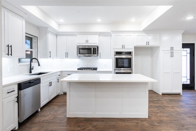 kitchen featuring a center island, sink, white cabinetry, and stainless steel appliances