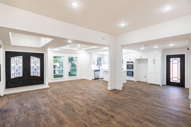 entryway featuring french doors, a tray ceiling, dark wood-type flooring, and sink