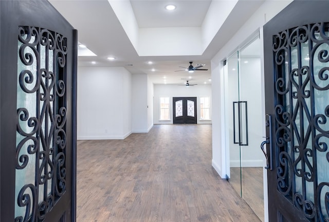 foyer featuring hardwood / wood-style floors, ceiling fan, and a tray ceiling