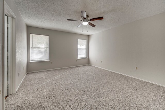 empty room featuring ceiling fan, carpet floors, and a textured ceiling