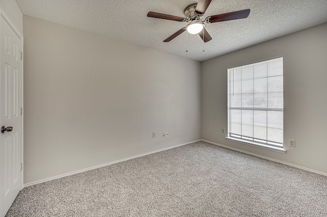 carpeted spare room with a textured ceiling, ceiling fan, and a healthy amount of sunlight