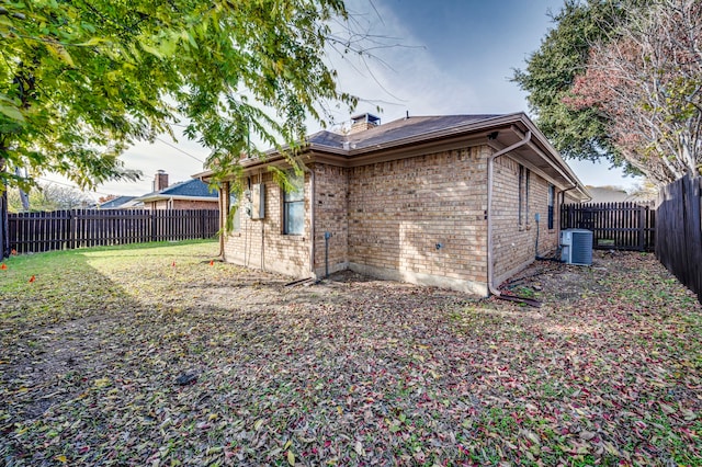 exterior space featuring central AC unit and a lawn