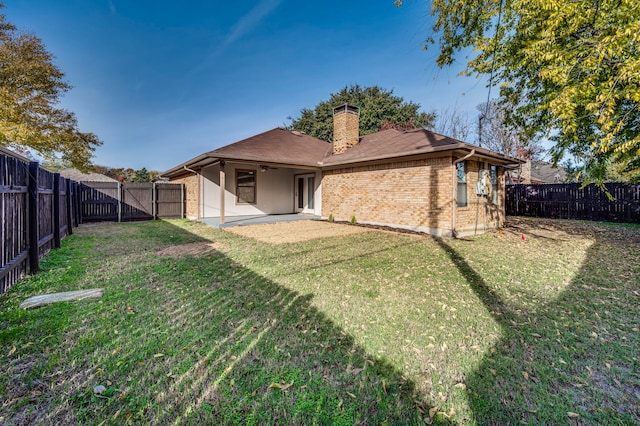 back of property with a lawn and a patio area