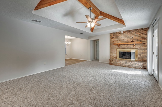 unfurnished living room featuring beamed ceiling, carpet, a textured ceiling, and a fireplace