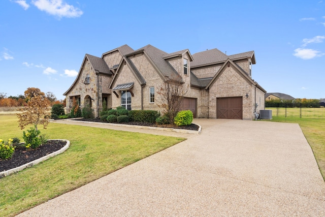 view of front of house with a garage, a front lawn, and central air condition unit