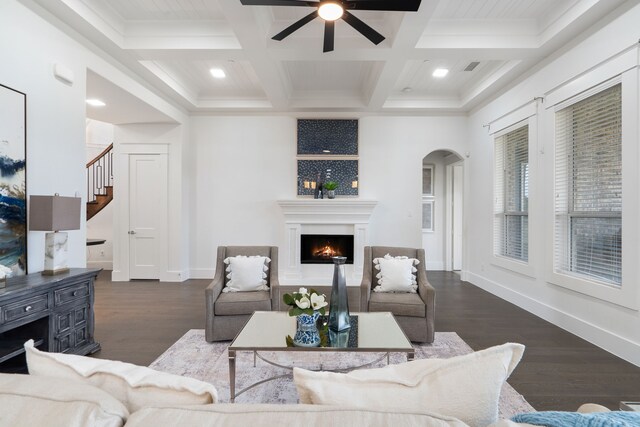 living room featuring beamed ceiling, ornamental molding, coffered ceiling, and dark wood-type flooring