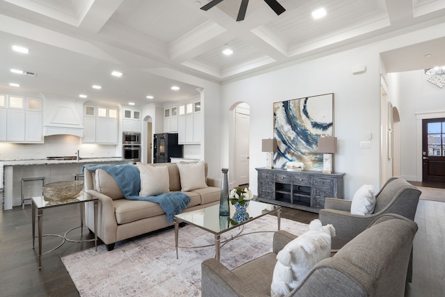 living room with coffered ceiling, ceiling fan, hardwood / wood-style flooring, and beamed ceiling