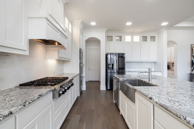 4509 Montalcino Blvd, Flower Mound, TX 75022 - kitchen with appliances with stainless steel finishes, arched walkways, white cabinetry, tasteful backsplash, and dark wood-style floors