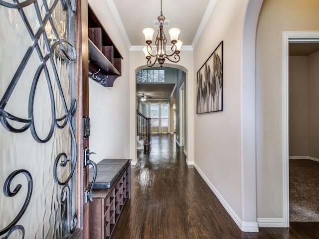 hallway with dark hardwood / wood-style flooring, a notable chandelier, and ornamental molding