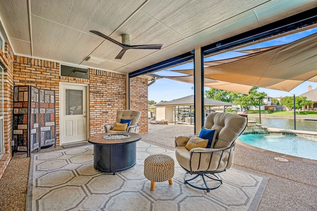 view of patio featuring a water view, ceiling fan, pool water feature, and a fire pit