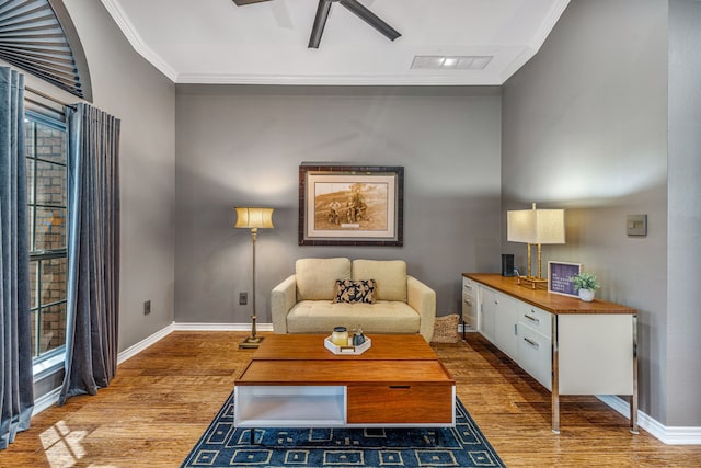 living room featuring ceiling fan, light hardwood / wood-style floors, and ornamental molding