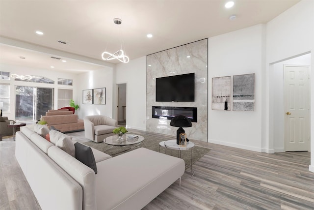 living room with visible vents, wood finished floors, recessed lighting, a fireplace, and baseboards