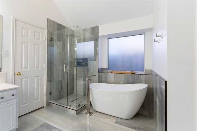 bathroom with plus walk in shower, vanity, tile walls, and lofted ceiling