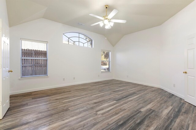 empty room featuring plenty of natural light, ceiling fan, dark hardwood / wood-style flooring, and lofted ceiling