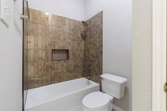 bathroom with toilet and tiled shower / bath