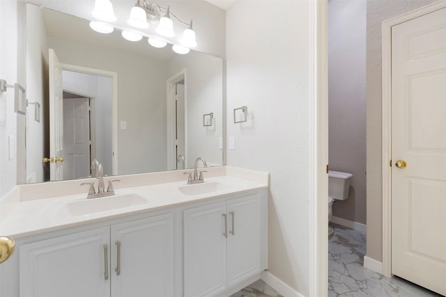 full bathroom featuring double vanity, marble finish floor, baseboards, and a sink