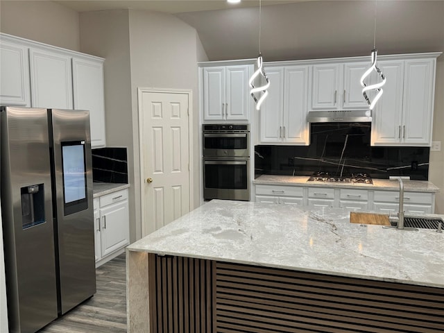 kitchen featuring a sink, decorative backsplash, stainless steel appliances, white cabinets, and under cabinet range hood