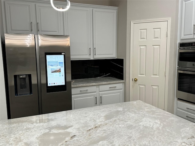 kitchen featuring stainless steel appliances, tasteful backsplash, and white cabinetry