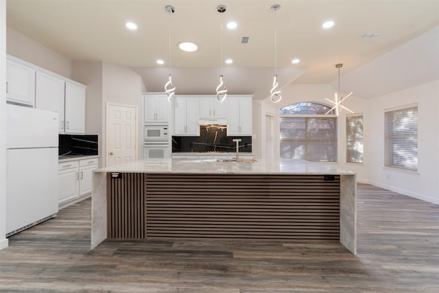 kitchen with white cabinetry, pendant lighting, vaulted ceiling, a spacious island, and white appliances