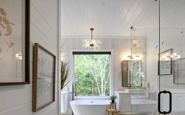 bathroom with an inviting chandelier, a bath, tile walls, and wooden ceiling