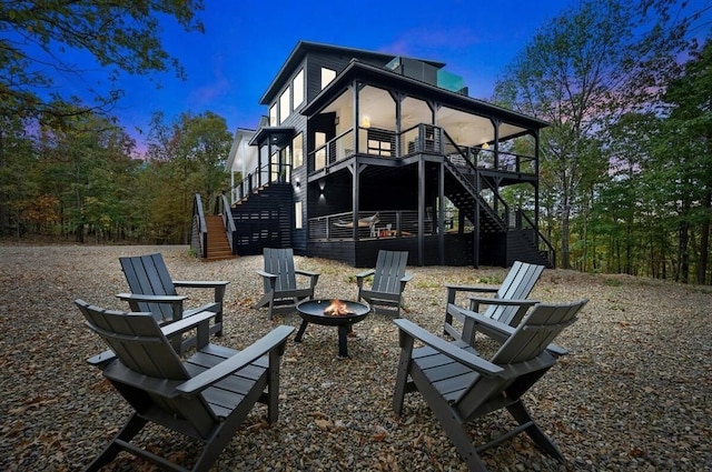 back house at dusk featuring an outdoor fire pit