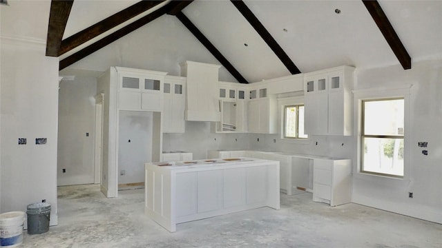 kitchen featuring white cabinets, beam ceiling, high vaulted ceiling, and a kitchen island