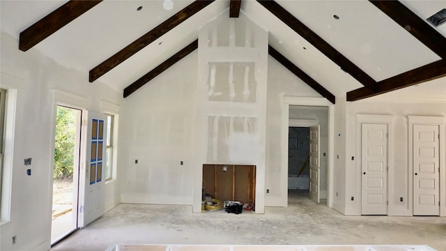 unfurnished living room with beam ceiling and high vaulted ceiling