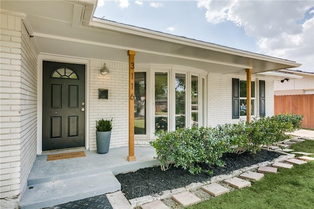 view of exterior entry featuring covered porch