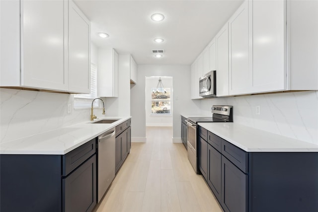 kitchen with sink, white cabinets, and appliances with stainless steel finishes