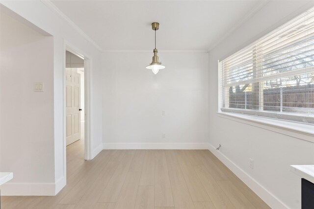 empty room with crown molding and light wood-type flooring