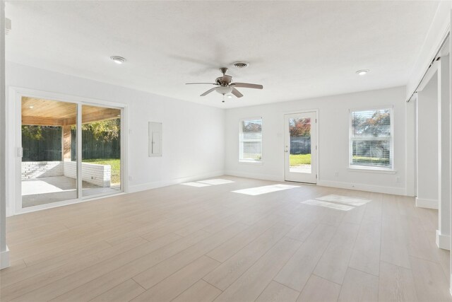 empty room featuring ceiling fan, light hardwood / wood-style floors, and electric panel