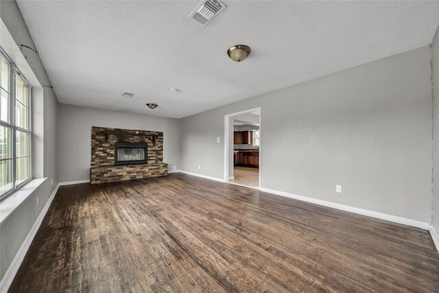 unfurnished living room with dark wood-type flooring and a textured ceiling