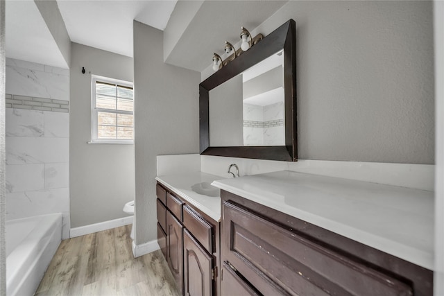 full bathroom with hardwood / wood-style floors, vanity, toilet, and tiled shower / bath combo