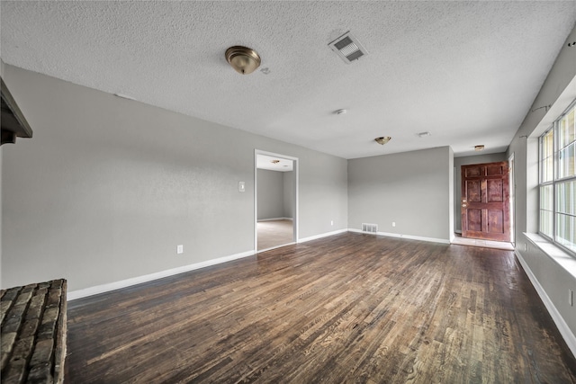 spare room with dark hardwood / wood-style flooring and a textured ceiling