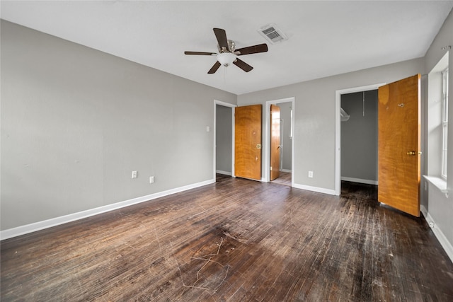 unfurnished bedroom with ensuite bath, ceiling fan, and dark wood-type flooring