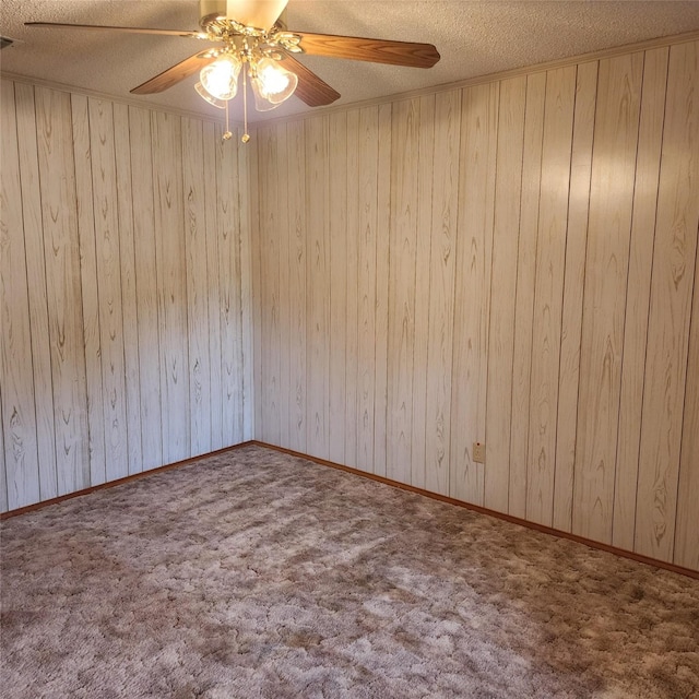 spare room featuring carpet flooring, a textured ceiling, and wooden walls