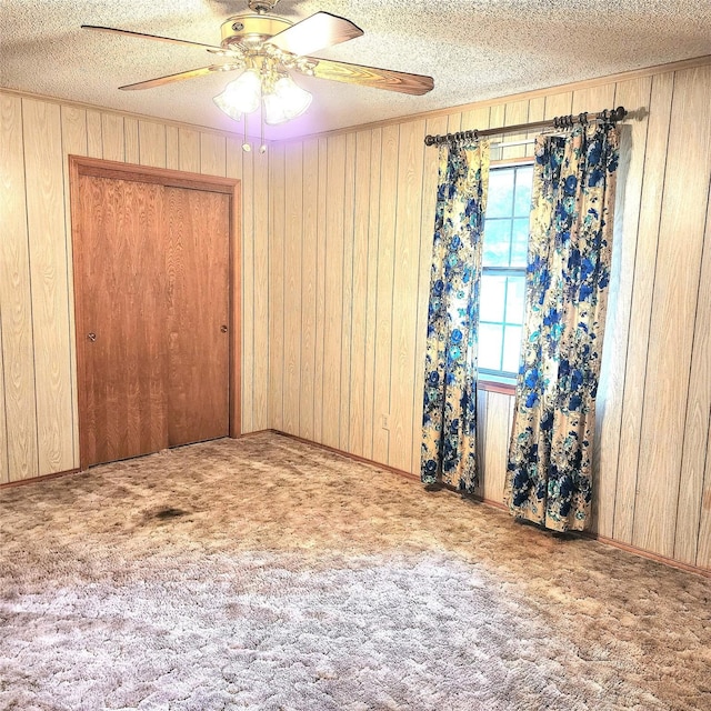 unfurnished room with a textured ceiling, light colored carpet, and ceiling fan